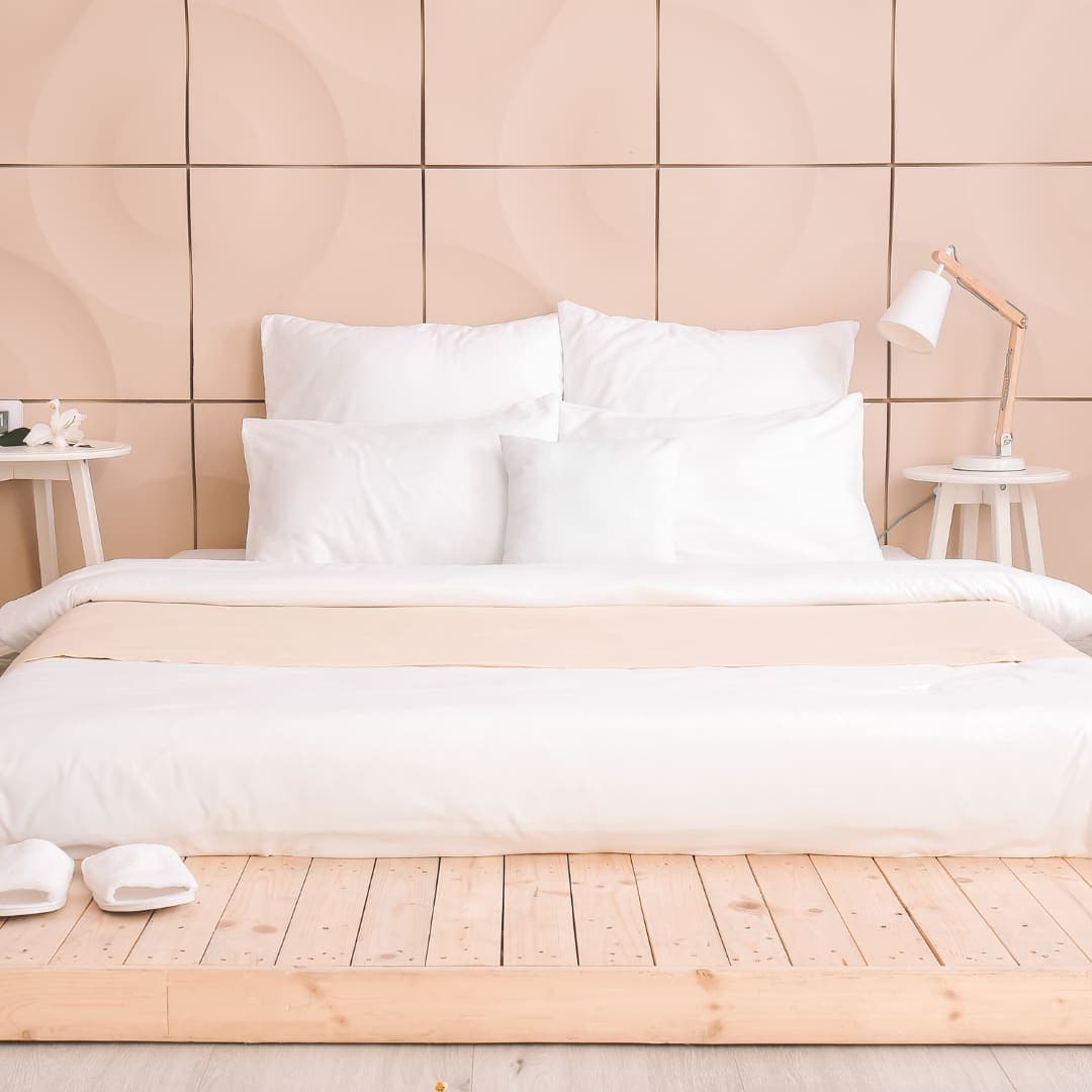 A freshly made bed with a white comforter
